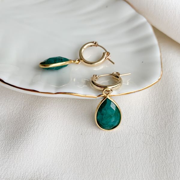 A piar of 14k gold filled hoop earrings with framed and faceted emerald charms in teardrop shape.